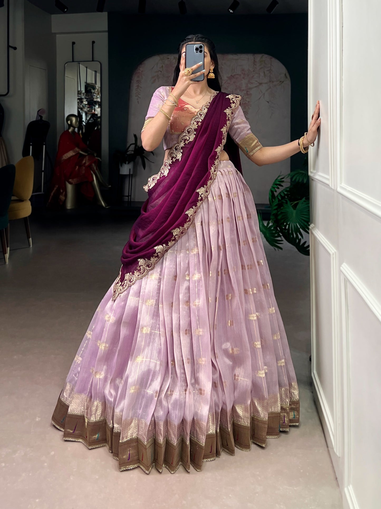 Woman wearing a traditional outfit with a purple and pink saree 