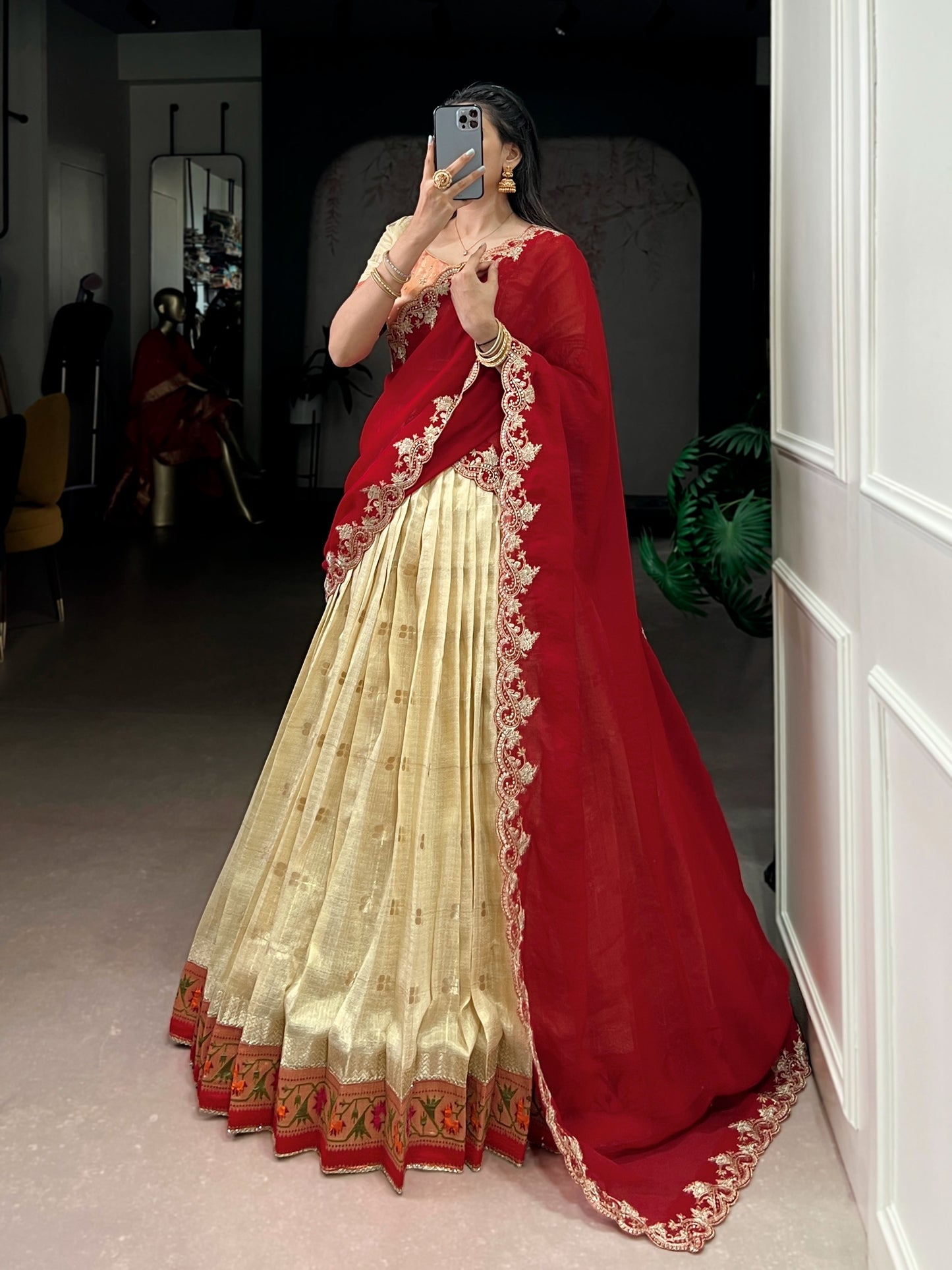 Person wearing a red and cream saree with intricate designs, 